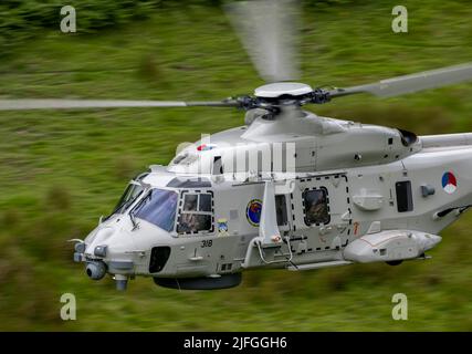 Royal Netherlands Navy, NH90 Helicopter in distacco nel Regno Unito a RNAS Culdrose, che effettua un addestramento di volo di basso livello nella zona di Mach Loop di Wale Foto Stock