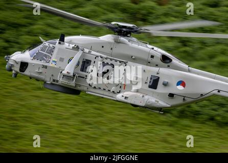 Royal Netherlands Navy, NH90 Helicopter in distacco nel Regno Unito a RNAS Culdrose, che effettua un addestramento di volo di basso livello nella zona di Mach Loop di Wale Foto Stock