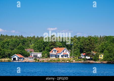 Paesaggio con alberi e case sull'isola di Uvö in Svezia. Foto Stock