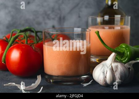 Primo piano della tipica zuppa spagnola di pomodoro (gazpacho andaluso) con pomodori freschi, peperoni verdi, aglio e olio d'oliva. Bicchiere di delizioso gazpacho. Foto Stock