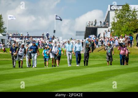 Il gruppo leader si dirige verso il fairway dalla 1st tee durante il loro ultimo round al LIV Golf Invitational London al Centurion Club Foto Stock