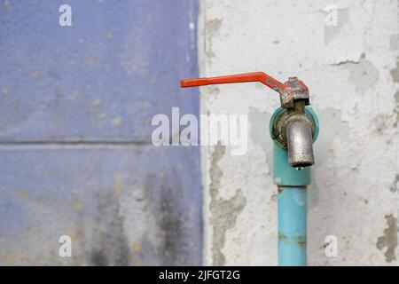 Vicino a rubinetto acqua in giardino su vecchio muro sfondo con spazio di copia per la progettazione Foto Stock