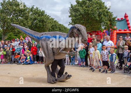 Dino Jurassic Live a Southport, Merseyside. UK Entertainment, Jurassic Live - incontra lo spaventosamente realistico spettacolo T-Rex Dinosaurs, un'avventura spaventosa nel Victoria Park far Away Land Family Festival. Jurassic World Live è un live show prodotto da Feld Entertainment e NBC Universal basato sul franchise Jurassic World. Le famiglie con bambini si sono recate al Victoria Park per una "Terra lontana" per vedere i dinosauri giganti animatronici che camminano, un'esperienza preistorica del fine settimana. Foto Stock