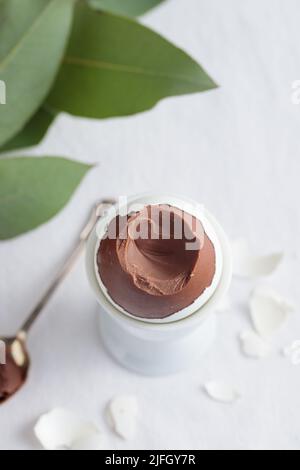 Uovo di cioccolato sul supporto bianco del supporto per le uova vista dall'alto Foto Stock