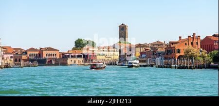 Paesaggio urbano dell'isola di Murano. Canale del mare con due traghetti, campanile del Duomo, Basilica dei Santi Maria e Donato, VII secolo. Venezia. Foto Stock