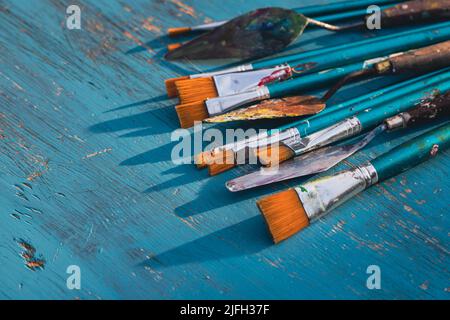 Arte artistica fornitura utensili con pennelli su sfondo di legno turchese con spazio copia. Foto Stock