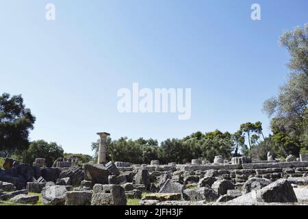 Scavi archeologici nell'antica Olimpia, Peloponneso. Paesaggio con pietre antiche (colonne), alberi e rocce. Olympia / Grecia - 15 luglio 2020 Foto Stock