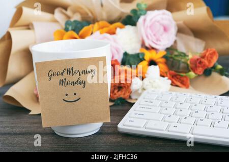 Buongiorno Lunedi saluto su una nota adesiva con una tazza di caffè Foto Stock
