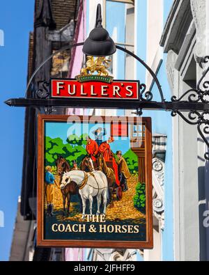 Londra, Regno Unito - 8th marzo 2022: Il tradizionale cartello da pub appeso all'esterno della casa pubblica Coach and Horses, situata in Greek Street nel SOH Foto Stock
