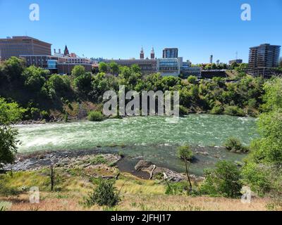 Il fiume Spokane scorre attraverso il centro di Spokane, Washington, in una mattinata estiva limpida e soleggiata. Foto Stock