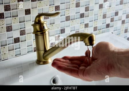 Ottone leva a gomito singolo miscelatore mono rubinetto in bagno, la mano è il controllo della temperatura dell'acqua. Foto Stock