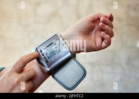 Sonometro elettronico per monitor della pressione sanguigna da polso e frequenza cardiaca con bracciale. Foto Stock