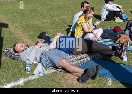 Questa mattina gli appassionati di tennis si accingono a fare lunghe code al Wimbledon Park per i biglietti in vista del campionato. Nella foto: I fan si prendere il sole mentre aspettano in coda Foto Stock