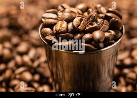 Chicchi di caffè appena tostato da vicino su sfondo scuro. Chicchi di caffè di fondo Foto Stock