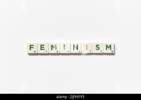 Femminismo formato da blocchi scrabble su sfondo bianco. Foto Stock