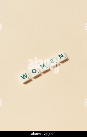 Donne formate da piastrelle scrabble su sfondo beige. Foto Stock