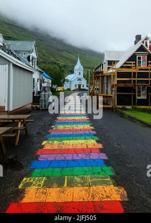 Seydisfjordur, Islanda - 23.June 2022: La famosa strada arcobaleno a Seydisfjordur con edifici islandesi intorno mostra pareti dipinte da opere d'arte Foto Stock