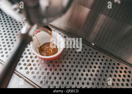 Vista ravvicinata della preparazione del caffè espresso in una macchina da caffè automatica nel caffè Foto Stock