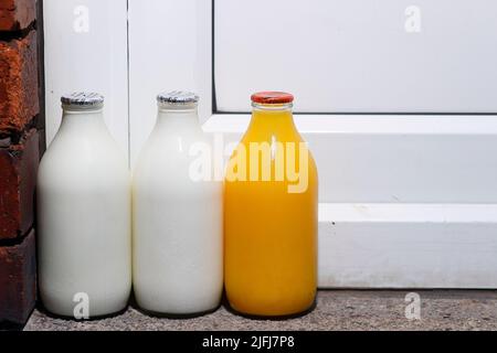 Pinte di latte e una pinta di succo d'arancia fresco a portata di mano consegnate da un milkman Foto Stock