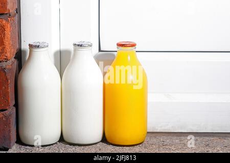 Pinte di latte e una pinta di succo d'arancia fresco a portata di mano consegnate da un milkman Foto Stock