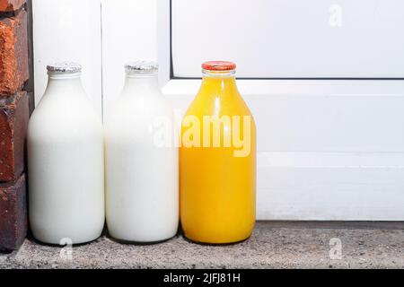 Pinte di latte e una pinta di succo d'arancia fresco a portata di mano consegnate da un milkman Foto Stock