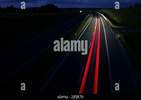 Traffico notturno in autostrada. Velocità, colori, prospettiva Foto Stock