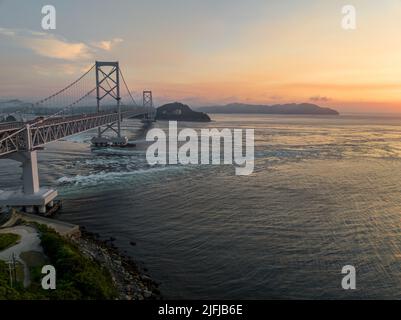 Ponte sospeso attraverso Naruto dritto e idromassaggi al tramonto Foto Stock