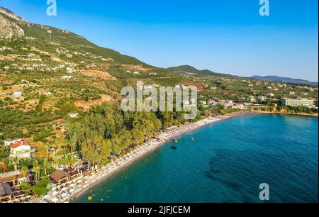 I turisti godono di vacanze estive nuotare alla spiaggia di Almyros nella cittadina balneare di Kato verga vicino Kalamata, Grecia. Foto Stock