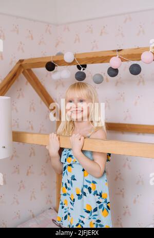 Camera per bambini in stile scandinavo: Cassettiera, bicicletta,  giocattoli, giocattolo per pianoforte, poltrona e vestiti su un  appendiabiti Foto stock - Alamy