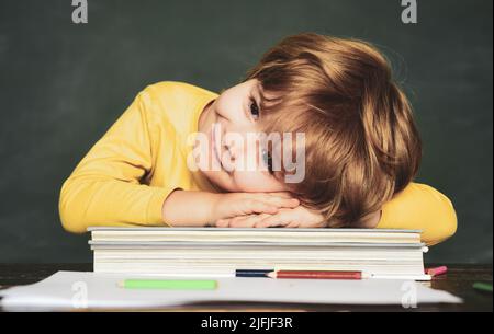 Schoolchild. Giornata degli insegnanti. Classe. Esame difficile. Ragazzi della scuola contro la lavagna verde. Imparare a casa. Concetto di educazione scientifica. Foto Stock