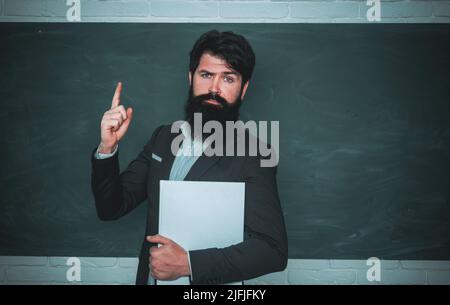 Concetto di apprendimento e istruzione. Concetto di formazione e apprendimento delle persone - insegnante femminile vicino alla lavagna. Professore in classe su sfondo lavagna Foto Stock