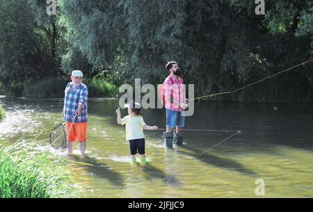 Nonno, padre e figlio pescano sul fiume Foto Stock