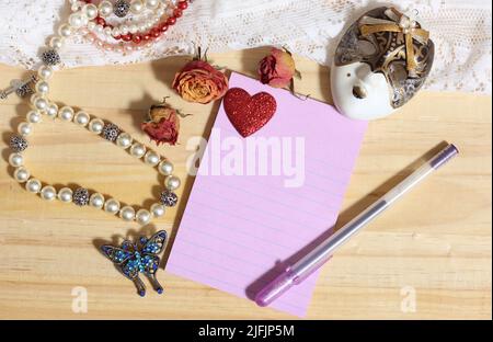 Perla Gioielleria e broccia di farfalla con pizzo e rose secche su sfondo di legno con carta bianca Foto Stock