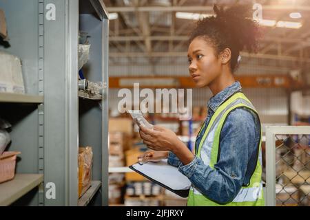 Il personale del magazzino delle donne africane nere gestisce le merci dei prodotti della fabbrica e la spedizione al cliente. Foto Stock