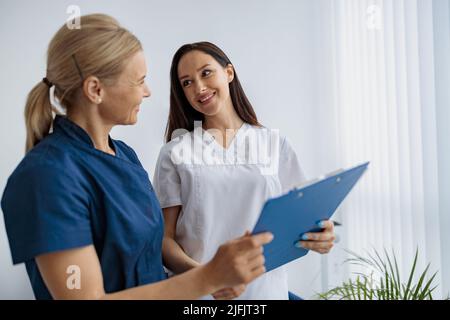 Medico e infermiere risolvere i problemi di lavoro in piedi nella sala clinica moderna Foto Stock