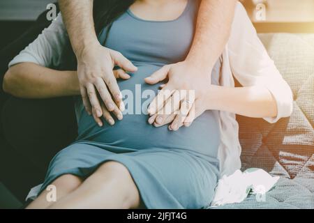 Gravidanza donna maternità nuovo bambino mamma con marito mano di copertura proteggere per amore cura nuovo concetto di famiglia. Foto Stock