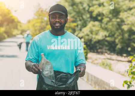 Ritratto Volontario persone nere pulizia rifiuti plastica spazzatura bottiglia per salvare l'ambiente in Earth Day. Foto Stock