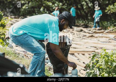 Volontariato pulizia rifiuti e inquinamento per salvare l'ambiente nella Giornata della Terra. Foto Stock