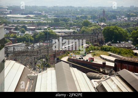 Il tetto della stazione di Manchester Piccadilly con un treno locale che si avvicina con le vecchie piattaforme per Mayfield sulla destra Foto Stock