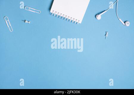 Cuffie, open notebook Music Concept. Vista dall'alto con spazio di copia su sfondo blu Foto Stock