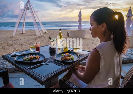 Cena donna asiatica durante il tramonto sulla spiaggia a Phuket Thailandia Khao Lak Foto Stock