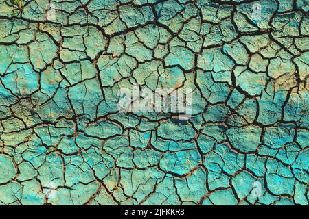Liquido chimico blu essiccato su terreni secchi e fessurati, danni ambientali e inquinamento Foto Stock