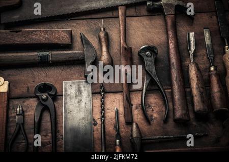 primo piano immagine di arrugginiti vecchi utensili di carpenteria in legno, martello, pinza, trapano, quadrato Foto Stock