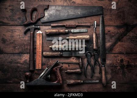 collezione vintage di vecchi utensili da carpenteria con martello, lima, piallatrice, pinza, crowbar e altro che illustra il concetto di artigianalità Foto Stock