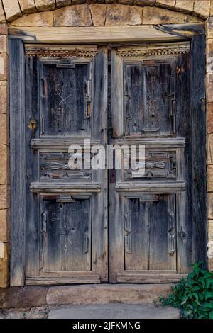 Antiche porte di legno nelle rovine del villaggio abbandonato di Gamsutl, Dagestan Foto Stock