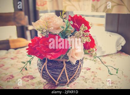 bel bouquet di fiori luminosi in cesto su tavola stile vintage. Foto Stock