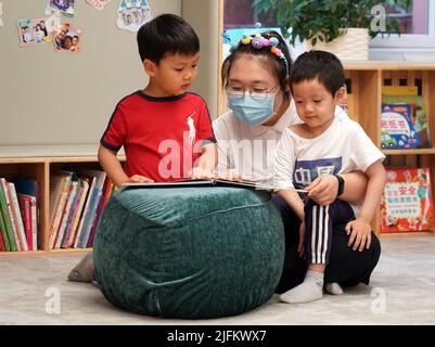 Pechino, Cina. 4th luglio 2022. I bambini leggono i libri come un asilo riapre a Pechino, capitale della Cina, 4 luglio 2022. Asilo nido a Beijng riaperto il lunedì. Credit: Ren Chao/Xinhua/Alamy Live News Foto Stock