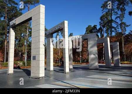 Kiev, Ucraina 22 ottobre 2021: Ingresso centrale al parco dell'arco 'Gloria Partisan' con il nome e cascata costruita Foto Stock