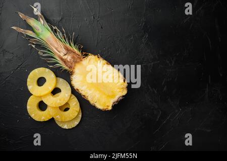 Fetta di ananas, su sfondo nero del tavolo in pietra scura, vista dall'alto piatta, con spazio di copia per il testo Foto Stock