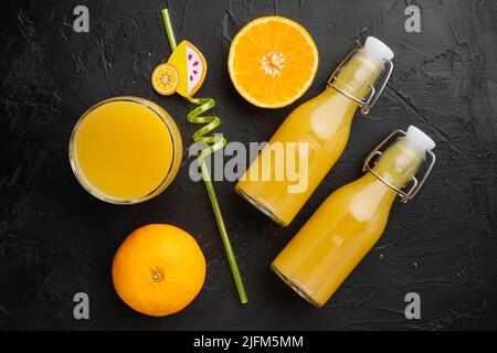 Succo d'arancia fresco, su fondo tavola in pietra scura nera, vista dall'alto, spianata Foto Stock